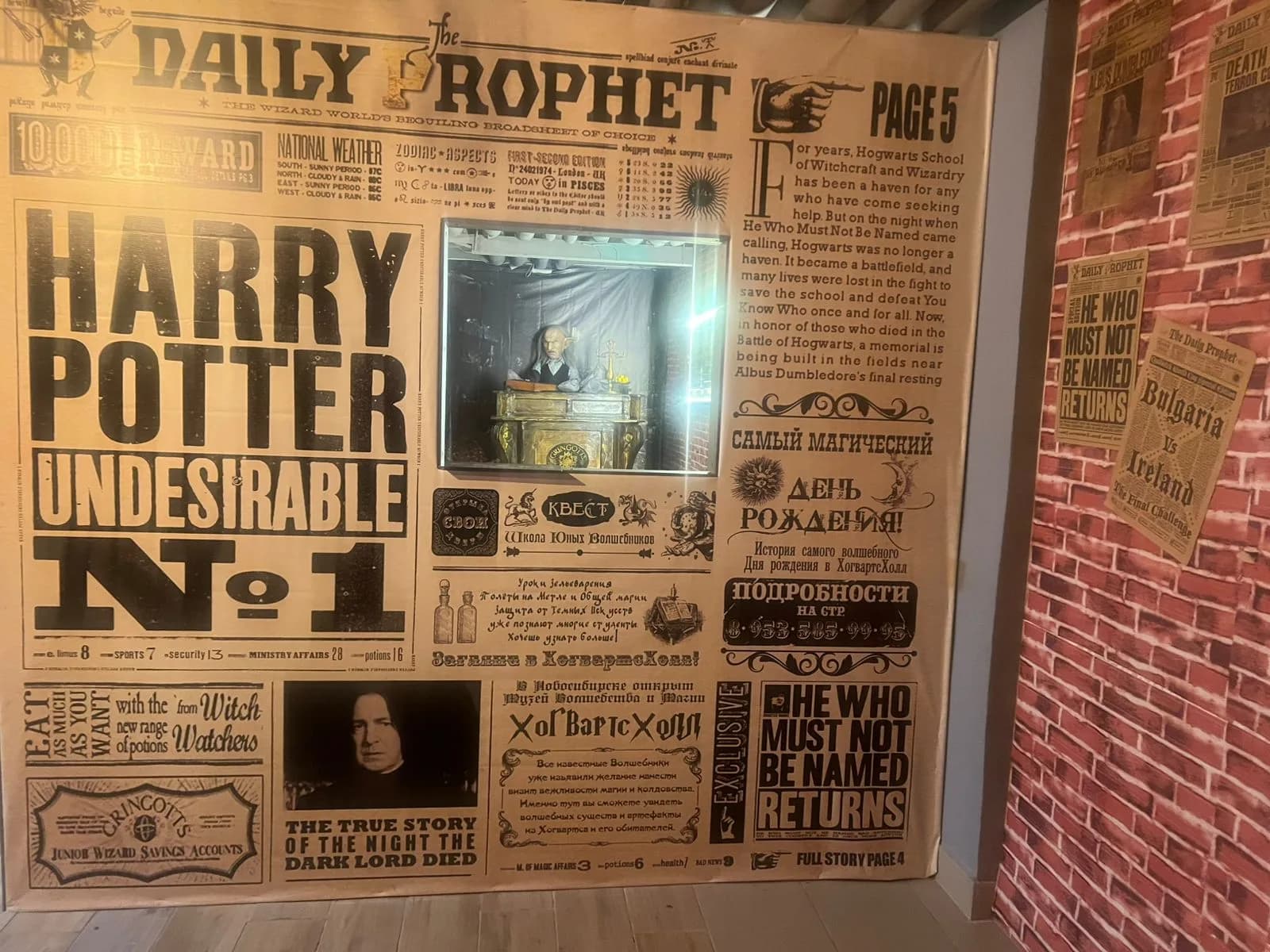 Стена-газета The Daily Prophet во всю высоту с витриной посередине и газетными вырезками рядом